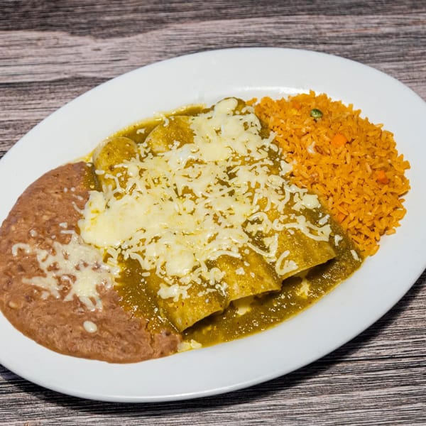 Three green enchiladas covered in melted cheese, with refried beans and orange rice on a white plate.