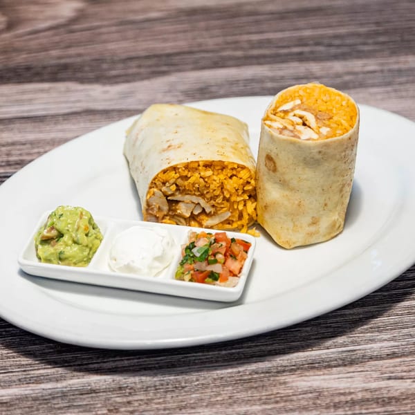 Two burritos with rice and chicken, served with guacamole, sour cream, and pico de gallo.