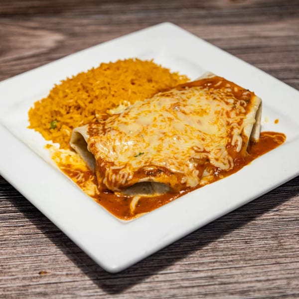 A cheesy burrito covered in red sauce and melted cheese, served with a side of orange rice.