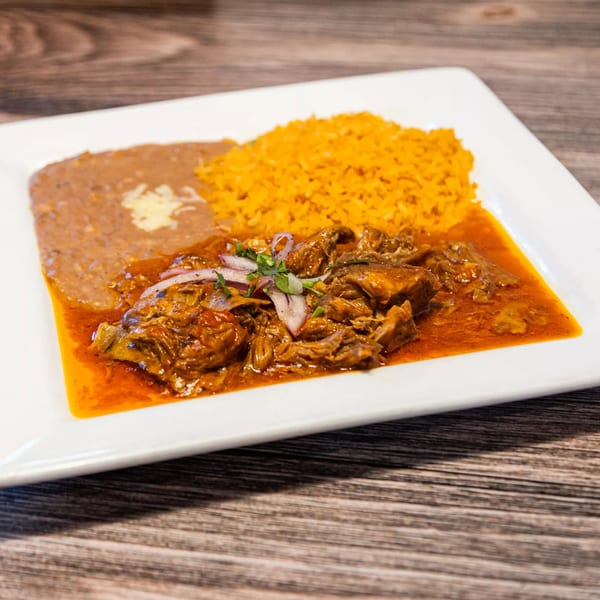Pancho Villa's Mexican dish with shredded meat in red sauce, rice, and refried beans.