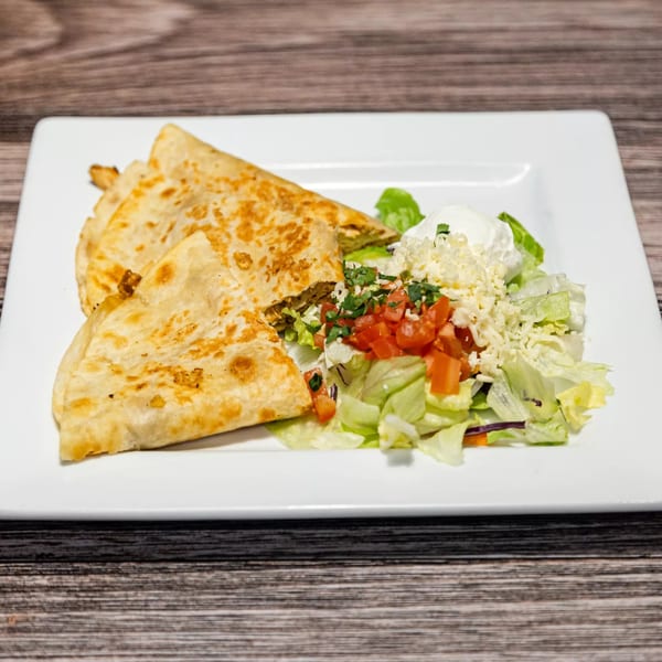 Pancho Villa's quesadilla with a side of fresh salad, diced tomatoes, and sour cream.